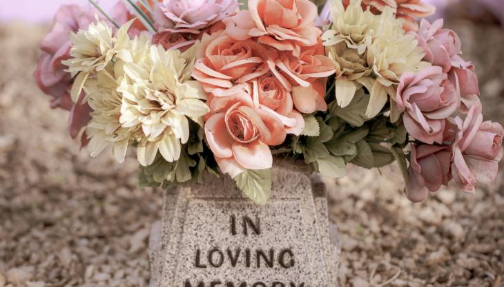 صورة زهور على مدفن مكتوب عليه: في ذكرى محبة.