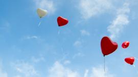 صورة لبالونات طائرة على شكل قلوب. 