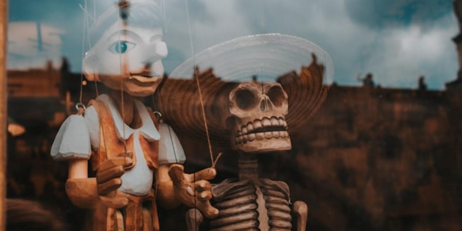 صورة لدمية بينوكيو إلى جانب هيكل عظمي.