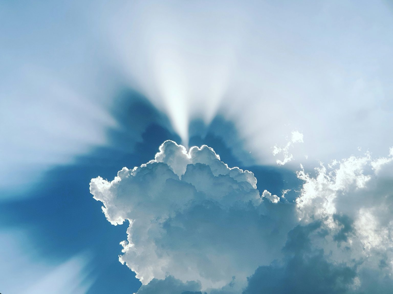 صورة لضوء من خلف غيمة بيضاء.